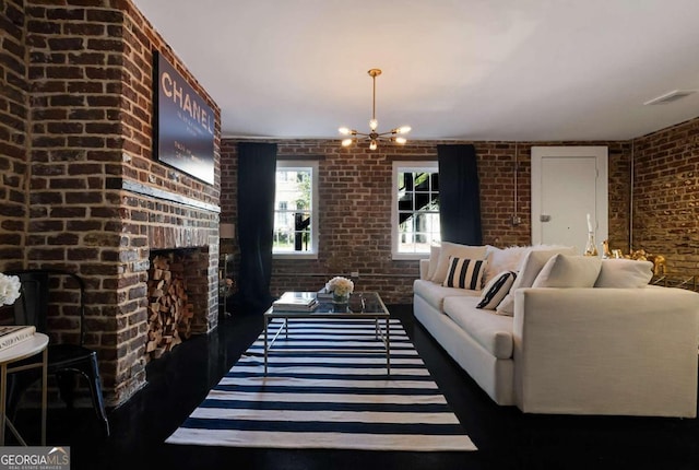 living room featuring a brick fireplace, brick wall, and a chandelier