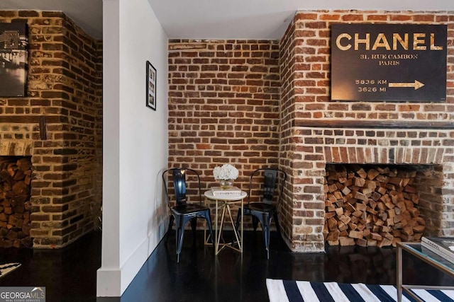 interior space with dark hardwood / wood-style flooring and brick wall