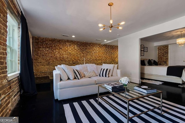 living room featuring brick wall and a notable chandelier