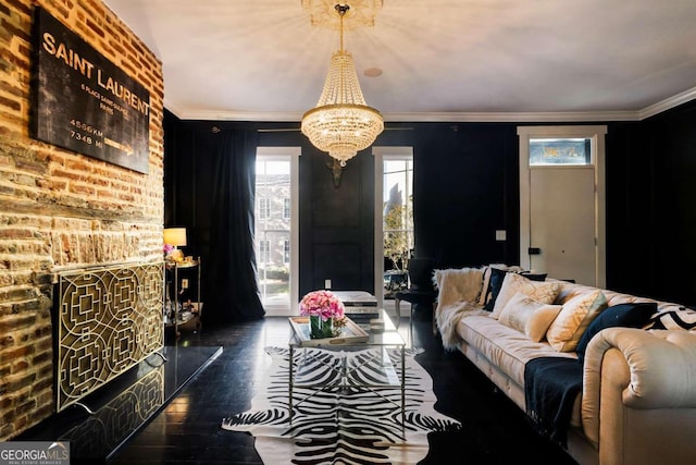 living room with ornamental molding, an inviting chandelier, and dark hardwood / wood-style floors