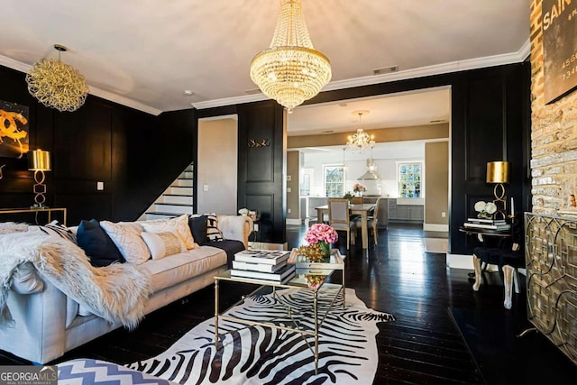 living room featuring an inviting chandelier, dark hardwood / wood-style floors, and crown molding