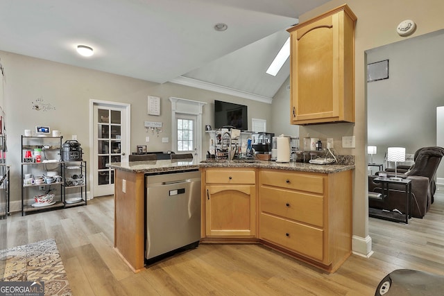 kitchen featuring lofted ceiling with skylight, kitchen peninsula, ornamental molding, stainless steel dishwasher, and light wood-type flooring