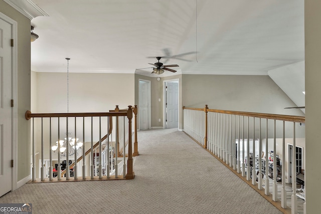 hall featuring light colored carpet, an inviting chandelier, lofted ceiling, and ornamental molding