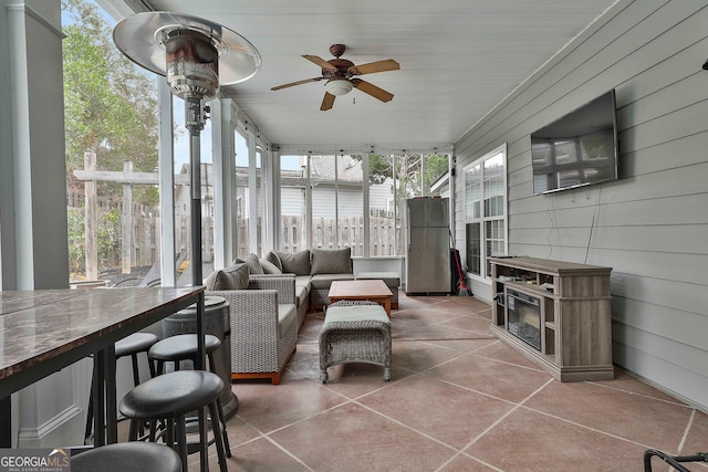 sunroom / solarium featuring ceiling fan