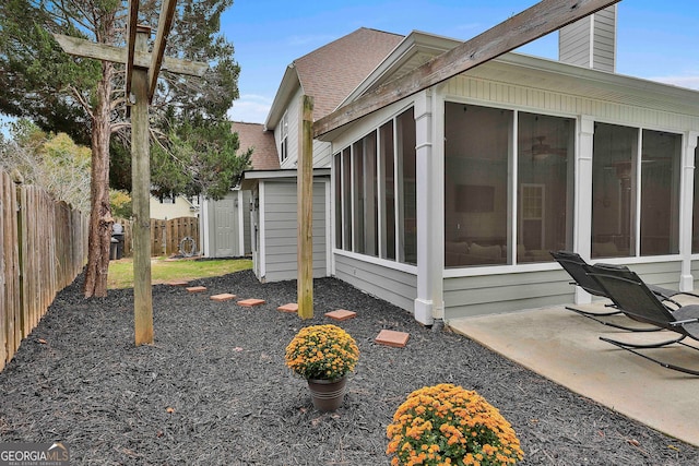 view of side of home featuring a patio area and a sunroom