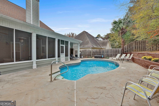 view of pool with a sunroom and a patio