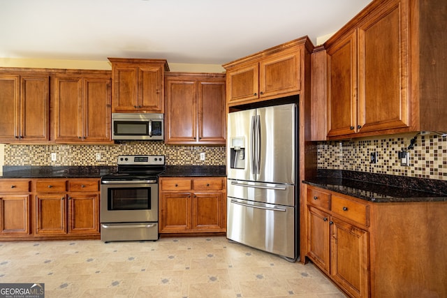 kitchen with dark stone countertops, backsplash, and stainless steel appliances