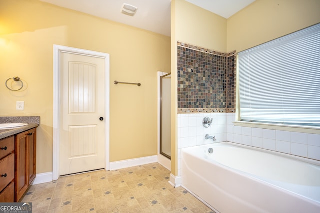 bathroom with vanity and shower with separate bathtub