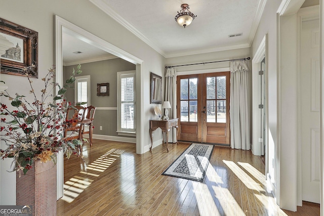 entrance foyer with visible vents, a healthy amount of sunlight, hardwood / wood-style floors, and french doors