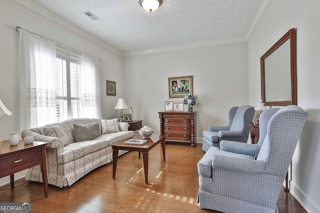 living area featuring visible vents, a textured ceiling, wood finished floors, and crown molding