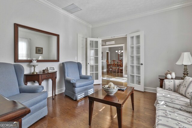 living room with hardwood / wood-style flooring, a textured ceiling, french doors, and ornamental molding