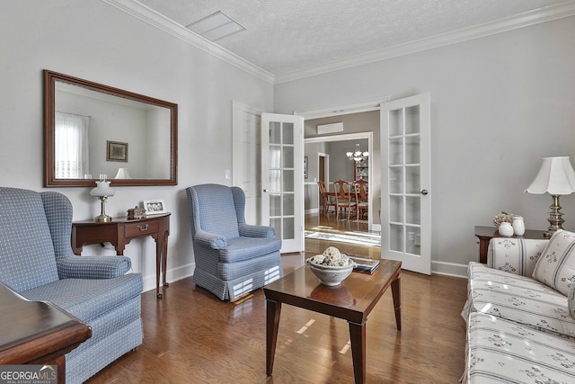 living area featuring a textured ceiling, wood finished floors, french doors, crown molding, and baseboards