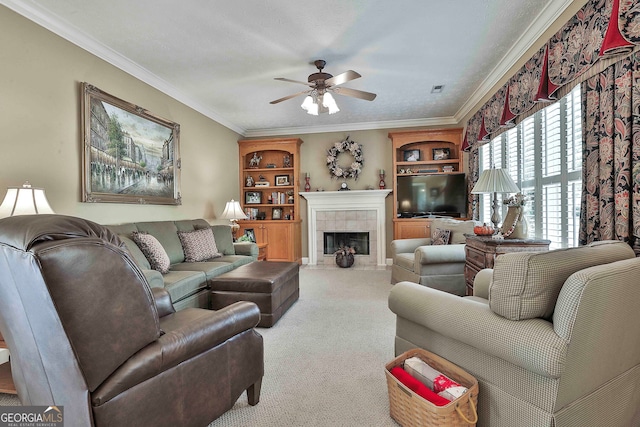 living room with ceiling fan, carpet, a tile fireplace, and ornamental molding