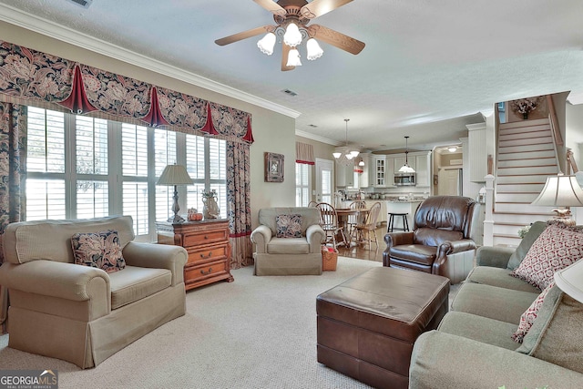 carpeted living room with ceiling fan, a textured ceiling, and ornamental molding