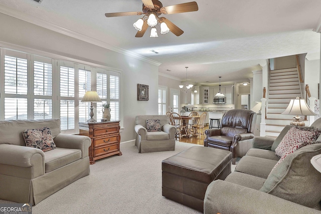 carpeted living area with a ceiling fan, stairs, baseboards, and ornamental molding