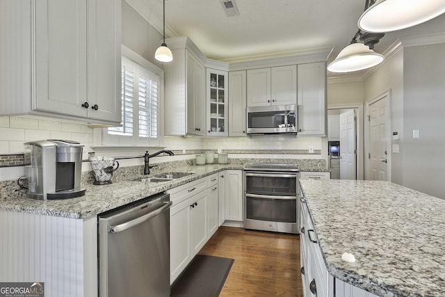 kitchen featuring visible vents, ornamental molding, a sink, dark wood-style floors, and appliances with stainless steel finishes