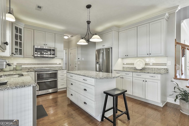 kitchen with dark wood finished floors, visible vents, appliances with stainless steel finishes, and a sink