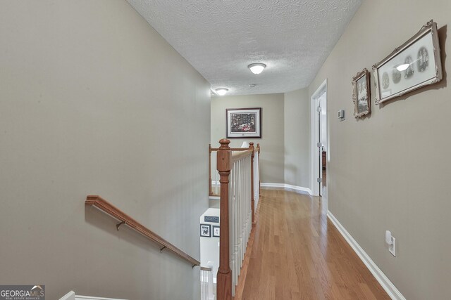 sitting room with light wood-type flooring and a textured ceiling