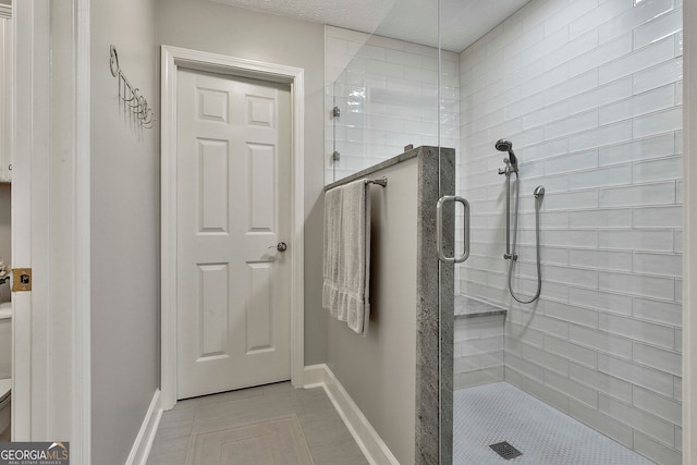 bathroom with tile patterned floors and a shower with door