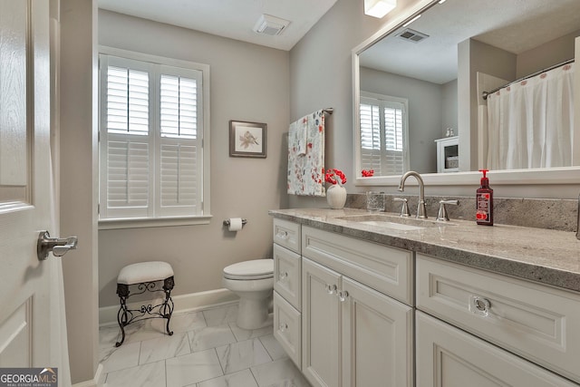 bathroom with vanity, plenty of natural light, and toilet