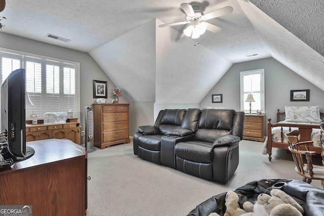 interior space with visible vents, light colored carpet, a textured ceiling, and vaulted ceiling