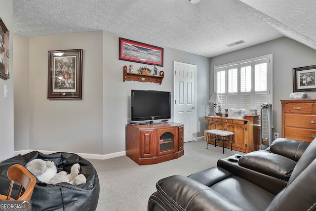 living room with a textured ceiling, light carpet, and vaulted ceiling