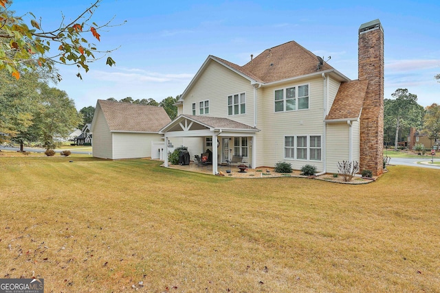 rear view of property with a garage and a yard