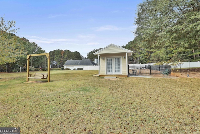 view of yard featuring french doors and fence