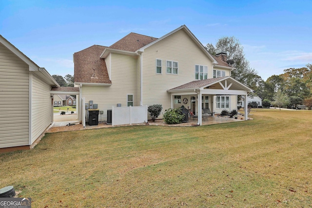 back of house featuring a patio and a yard