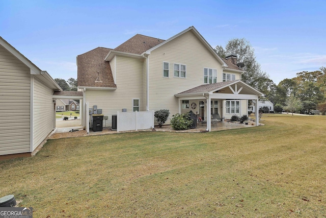 back of property with a patio area, central AC unit, a lawn, and roof with shingles