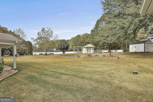 view of yard featuring an outbuilding, a shed, and a detached garage