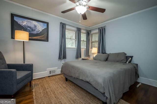 bedroom featuring ceiling fan, dark hardwood / wood-style flooring, and ornamental molding