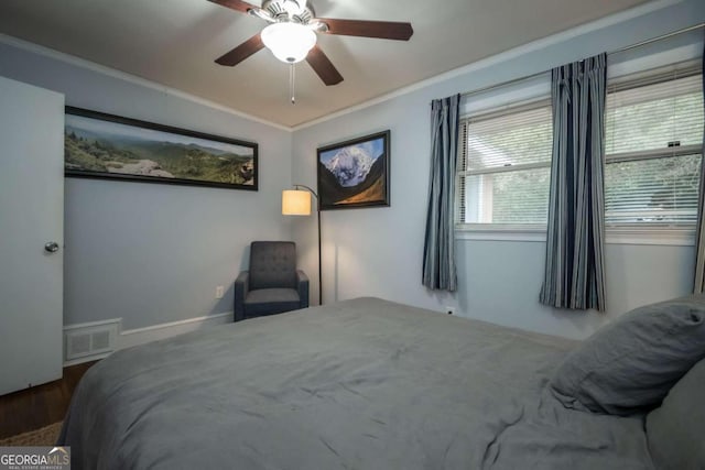 bedroom featuring dark hardwood / wood-style flooring, ceiling fan, and crown molding