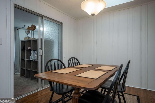 dining space featuring ornamental molding and dark hardwood / wood-style floors