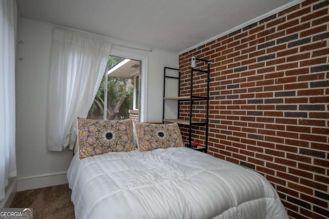 bedroom featuring crown molding, brick wall, and carpet floors