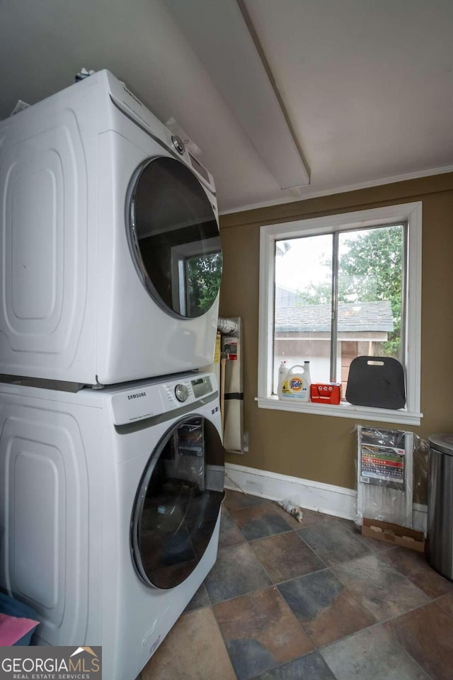 clothes washing area featuring stacked washer and clothes dryer