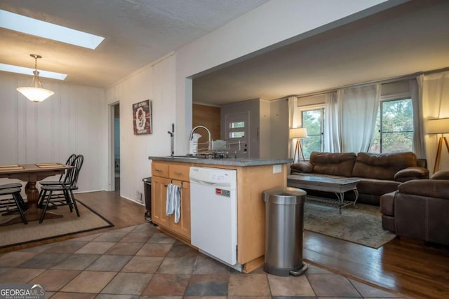 kitchen with dark hardwood / wood-style floors, a skylight, decorative light fixtures, and dishwasher