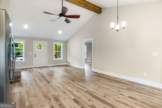 unfurnished living room featuring high vaulted ceiling, light wood-type flooring, ceiling fan with notable chandelier, and beam ceiling