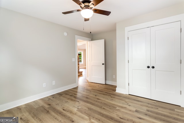 unfurnished bedroom featuring a closet, light wood-type flooring, and ceiling fan