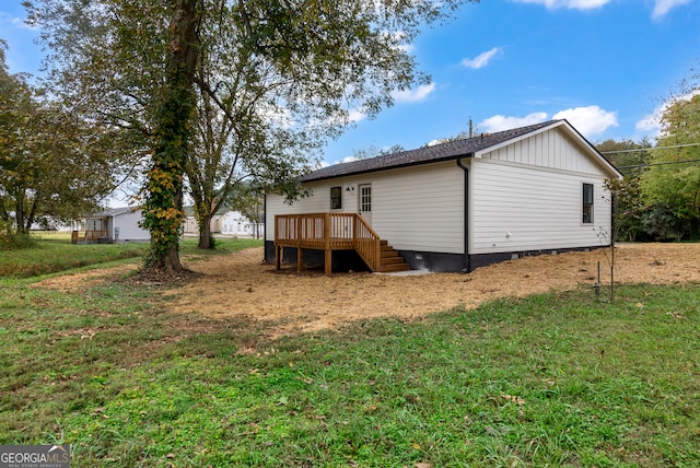 back of property with a lawn and a wooden deck