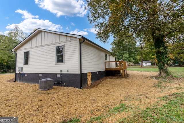 view of property exterior with central air condition unit and a wooden deck