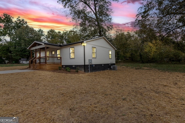 property exterior at dusk with central AC and a porch