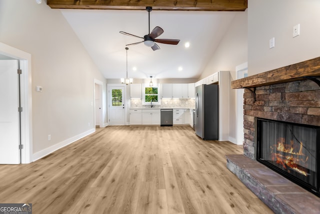 unfurnished living room featuring high vaulted ceiling, light wood-type flooring, a stone fireplace, and beam ceiling