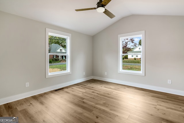 spare room featuring light hardwood / wood-style flooring, lofted ceiling, and ceiling fan