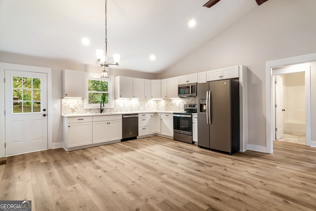 kitchen with white cabinets, high vaulted ceiling, light wood-type flooring, and appliances with stainless steel finishes