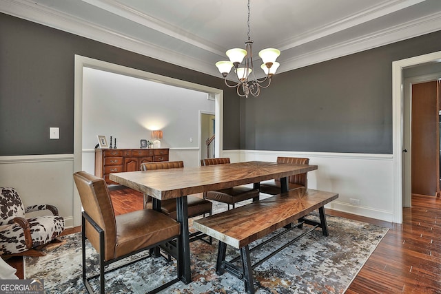 dining area featuring dark wood-type flooring, a chandelier, and crown molding