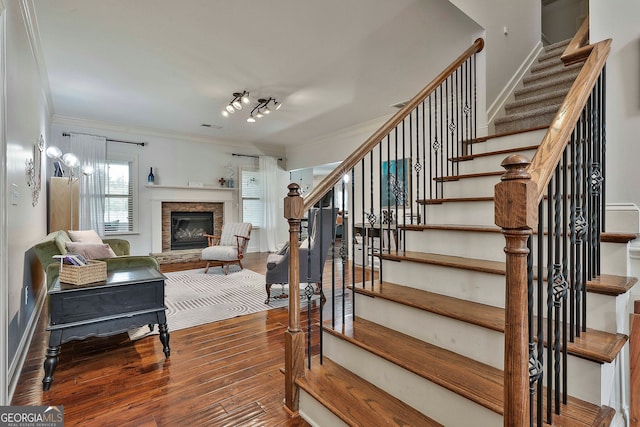 stairway with hardwood / wood-style flooring and crown molding