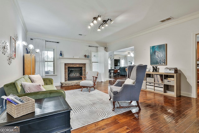 living room with ornamental molding, a fireplace, wood-type flooring, and ceiling fan