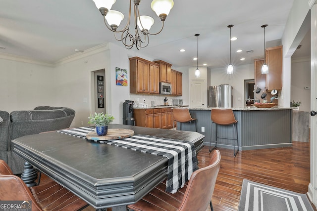 dining space with a notable chandelier, dark hardwood / wood-style floors, and crown molding