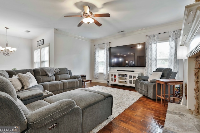 living room with ornamental molding, a wealth of natural light, dark hardwood / wood-style flooring, and ceiling fan with notable chandelier